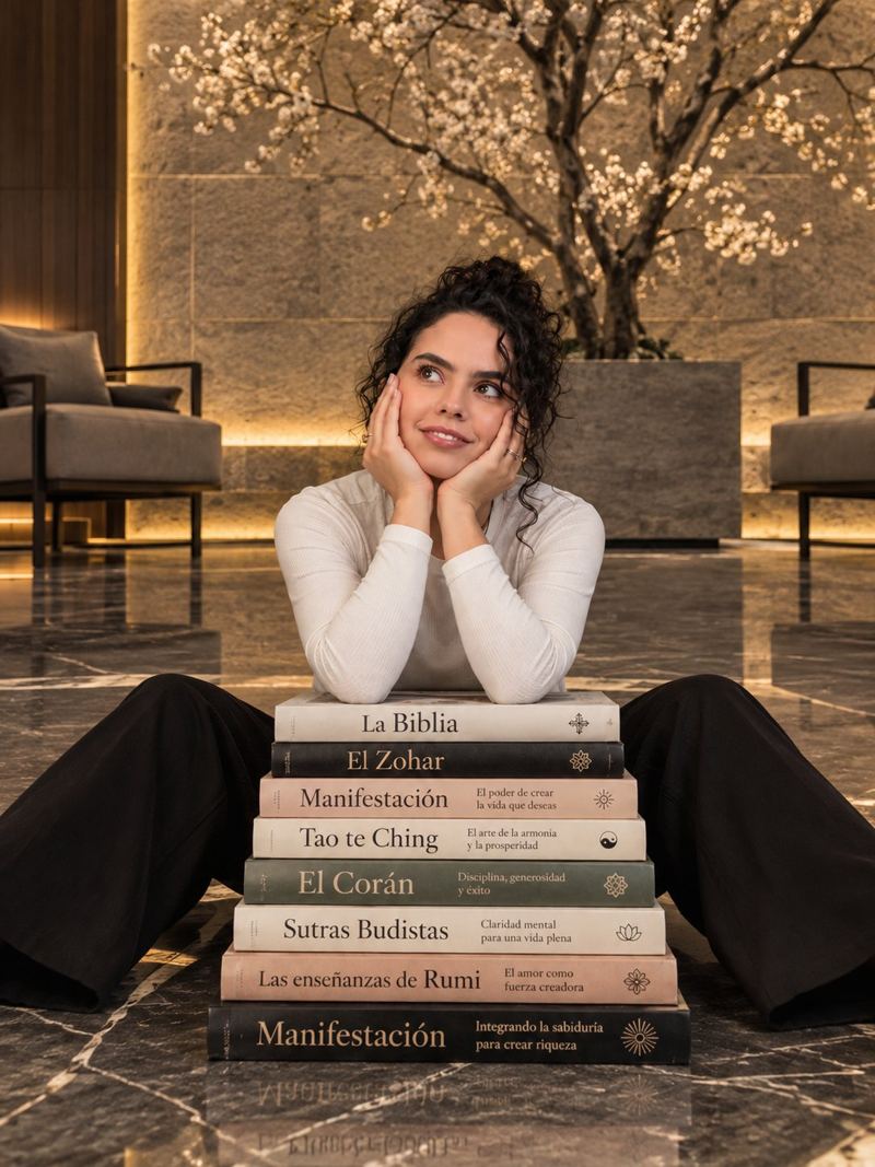 Karla Barajas con una pila de libros sagrados y de manifestación
